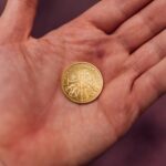 A gold coin resting in the palm of an open hand