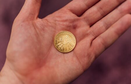 A gold coin resting in the palm of an open hand